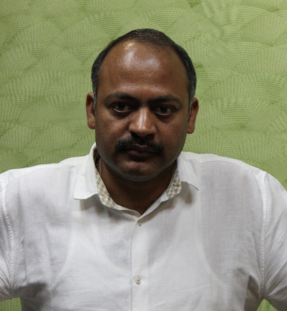 A person in a white t-shirt with green background.