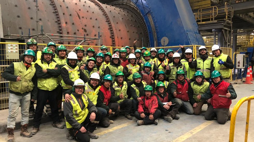 Team of maintenance employees pictured in front of a ball mill at Collahuasi mine.