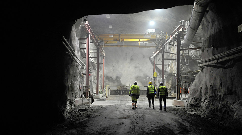 Three people pictured at an underground mine.