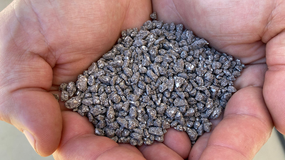 A scoop of fertilizers pictured in hands.