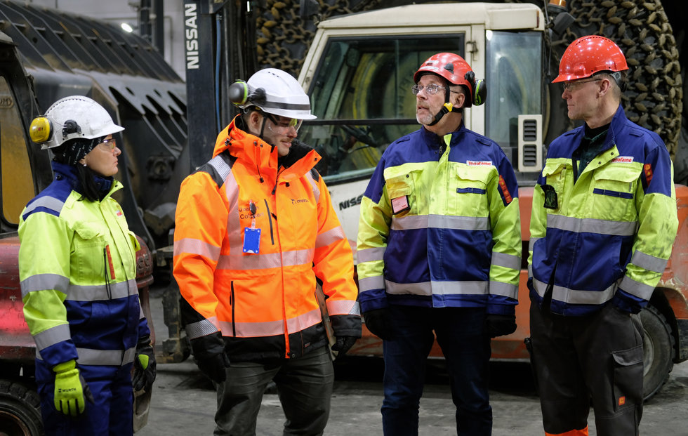 Four people in front of a truck at Terrafame mine.