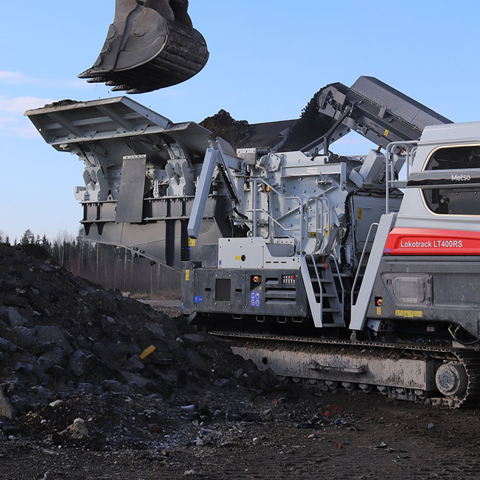 Large pieces of reclaimed asphalt pavement entering a mobile crusher