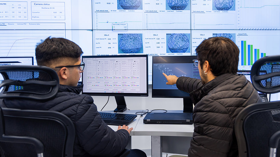 Two professionals checking real-time data on a computer screen