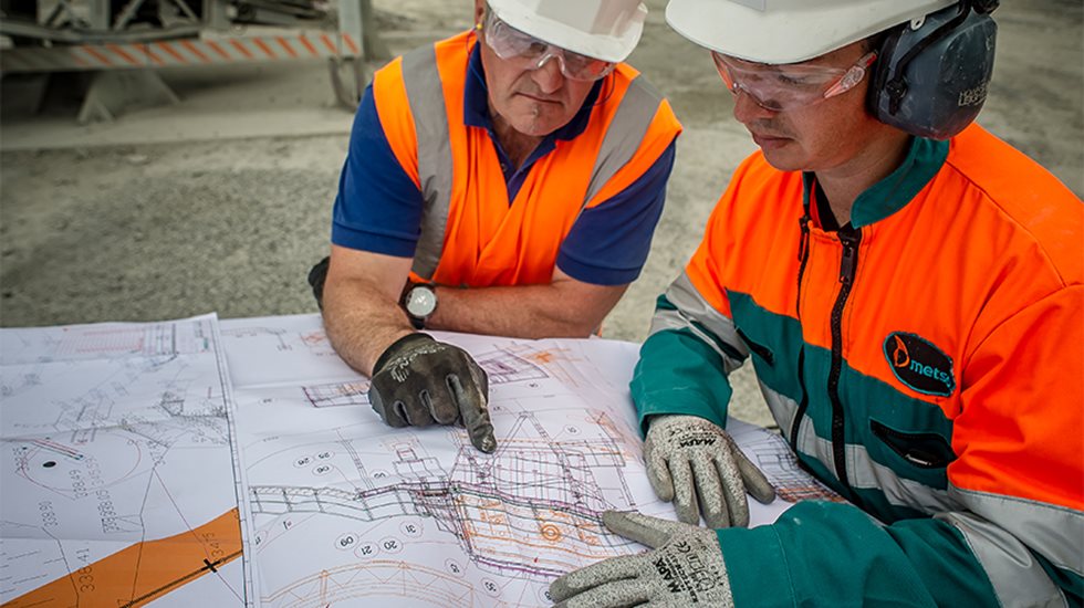 Two men in  a quarry looking at the setup plan.