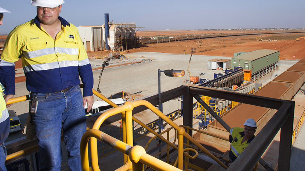 Two men at Fortescue Metal's site with scenery behind.