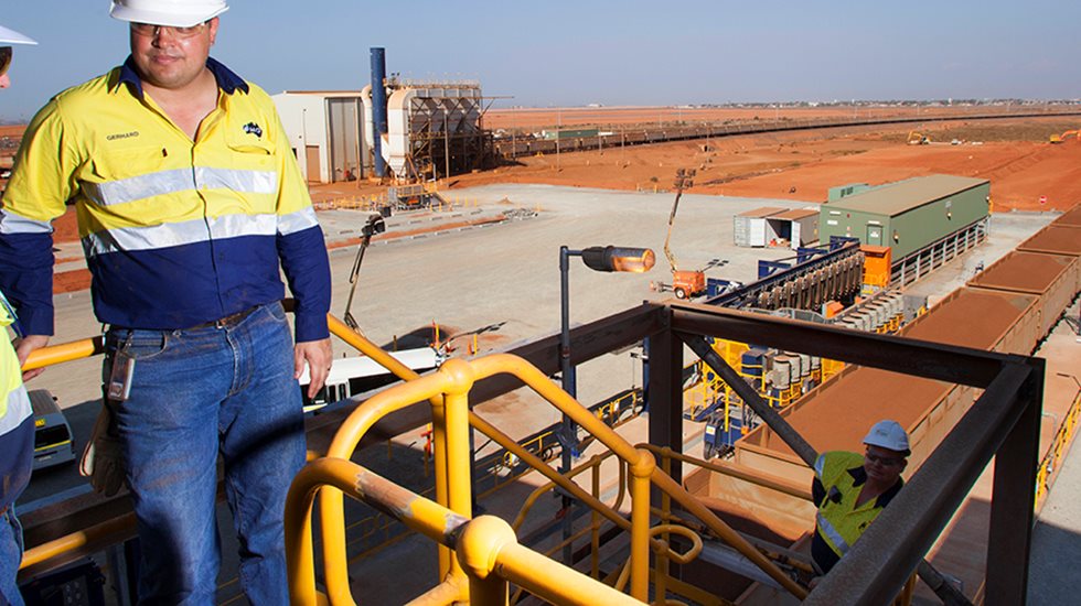 Two men at Fortescue Metal's site with scenery behind.
