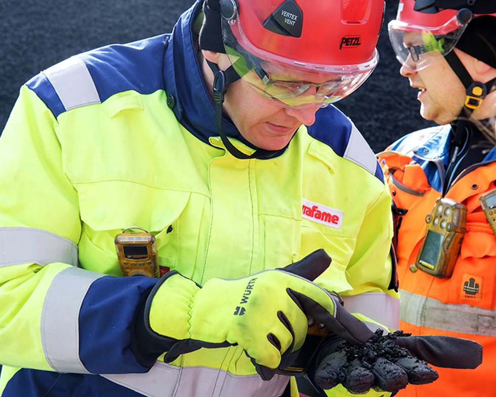 The dark ore that Jarkko Kettukangas is holding is crushed to 0-8 mm in four stages before arriving in the heap leach area.