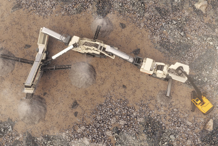 A Lokotrack equipment aparently working in a brown quary viewed from sky