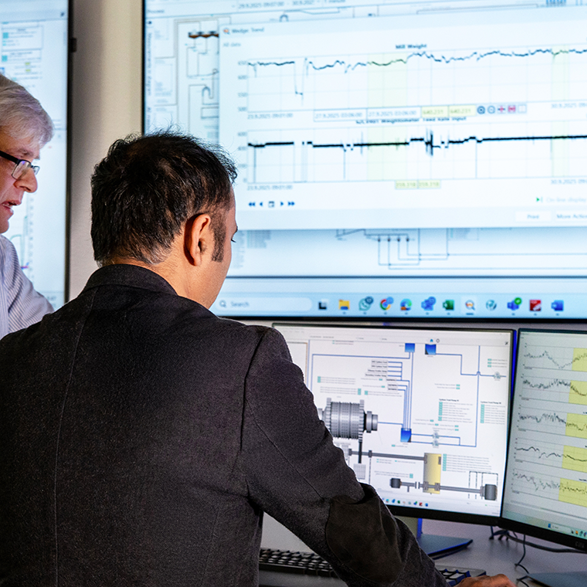 two men standing in front of metso performance analytics 