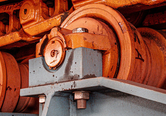 Underneath the pans of a feeder with orange chains