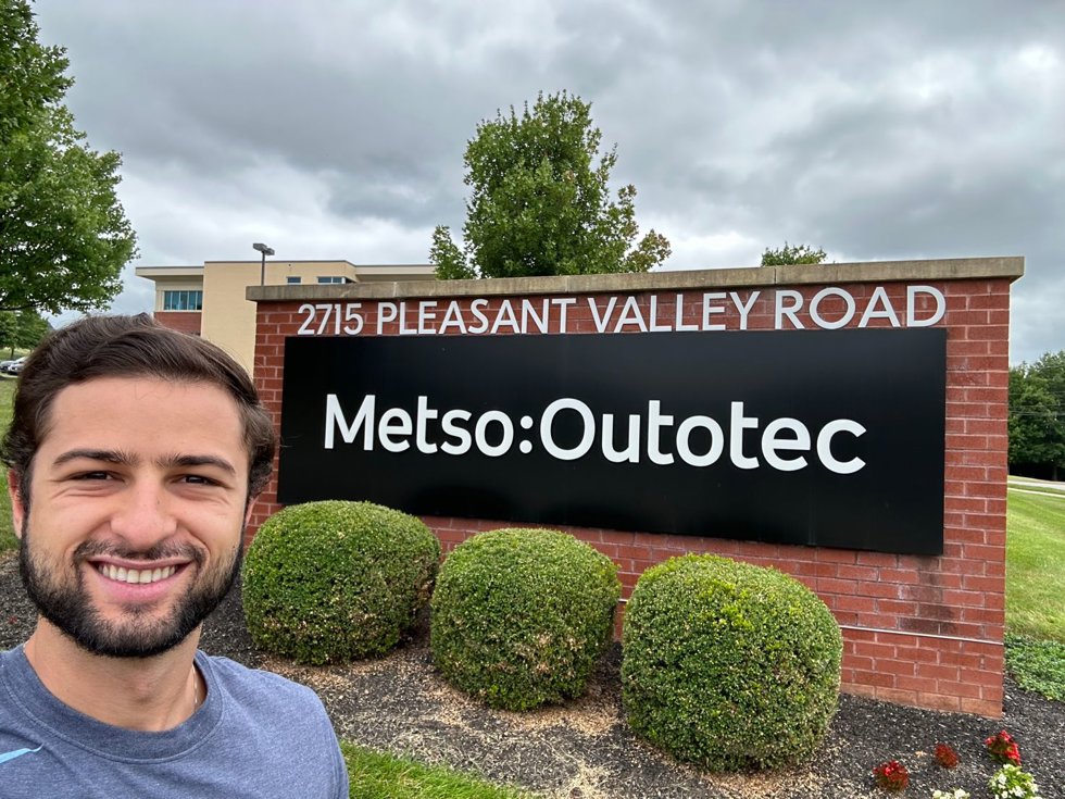 Henrique Rocha in front of Metso's office sign in York.