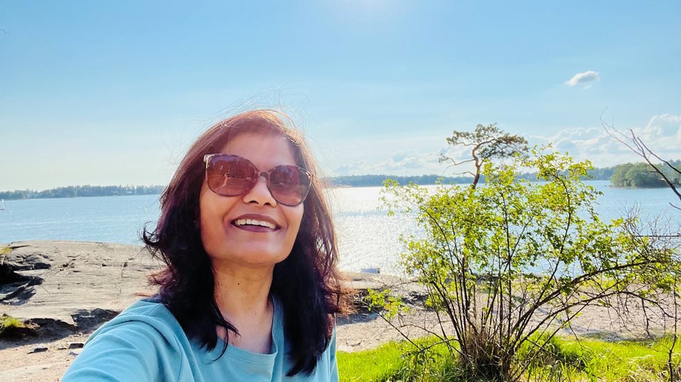 Rashmi Kasat smiling at the camera outside, wearing sunglasses.