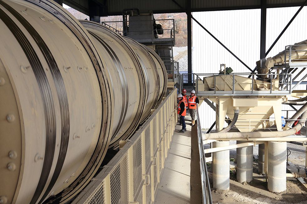Metso LD30120™ washing barrel pictured at a quarry with three people. 