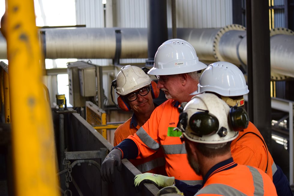 Four employees discussing at Glencore facility.
