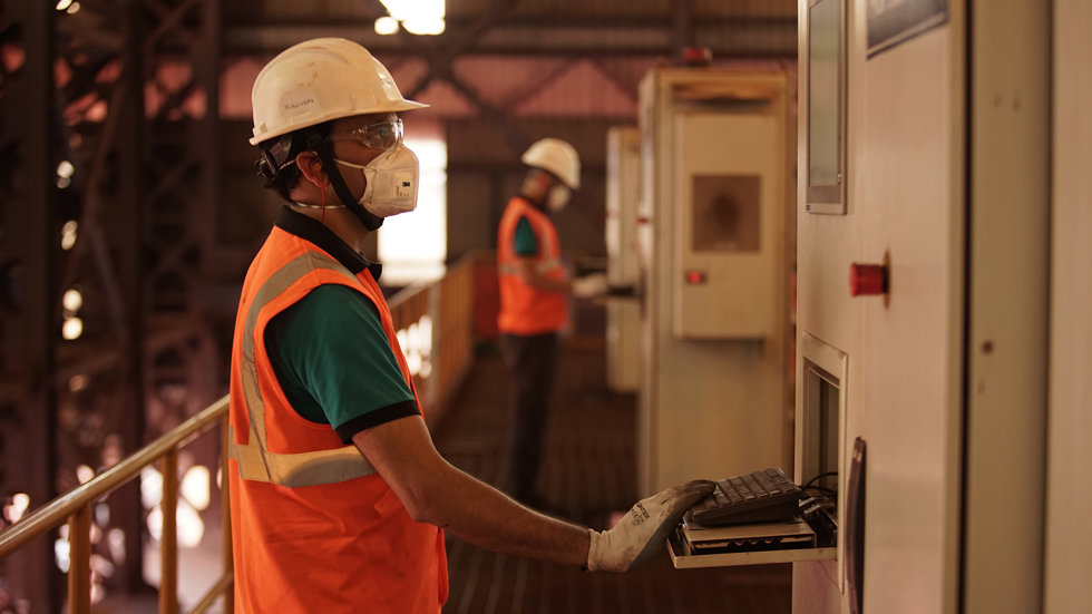 Two men working with plant controls at JSPL site.