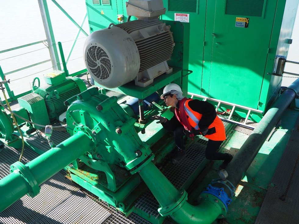 A woman inspecting a pump.